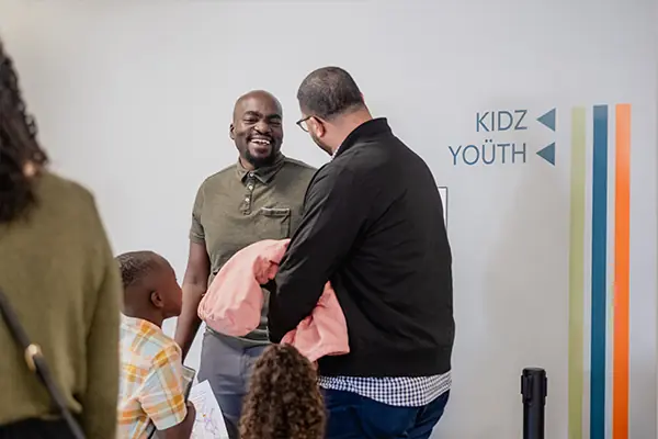A family being welcomed at a Cross Assembly Sunday service