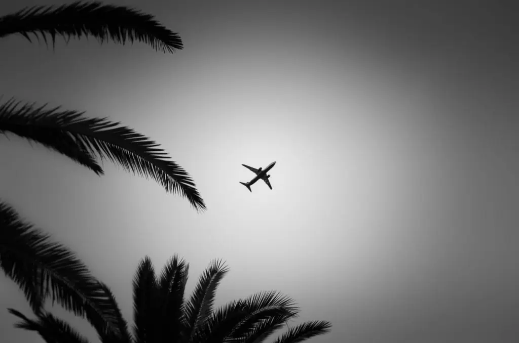 A passenger plane taking off into the sky, in black and white
